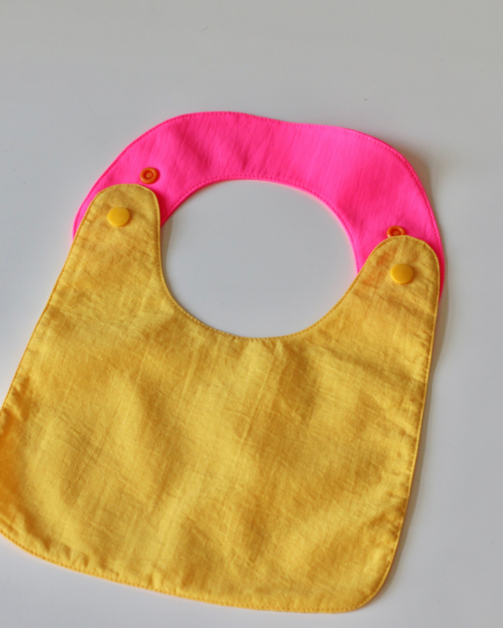Reversible Bib yellow/fuchsia