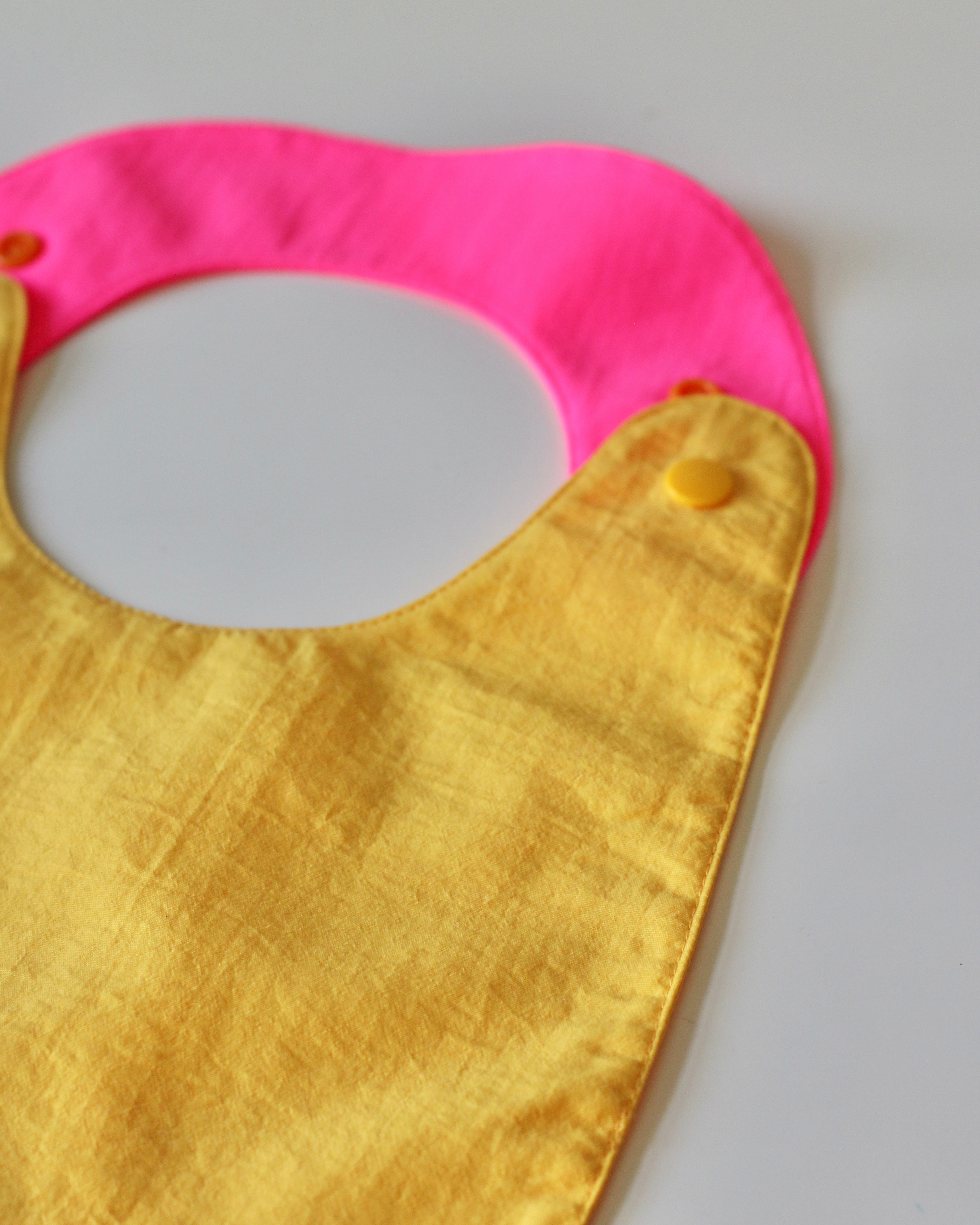 Reversible Bib yellow/fuchsia